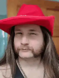 Man in red hat tipping brim