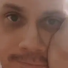 man resting cheek on hand