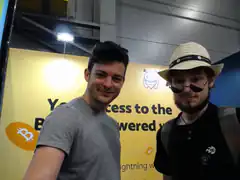 Two men at a Bitcoin Lightning booth