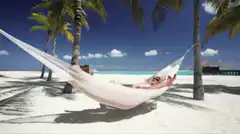 couple relaxing in hammock on beach