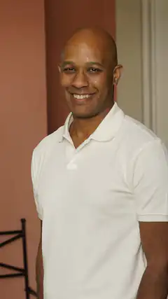 Smiling bald man in white polo shirt