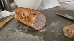 sliced cooked sausage on cutting board