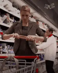 Woman breaks sausage in supermarket