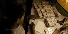 Man counting stacks of cash