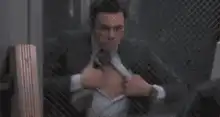 man ripping open shirt to reveal abs