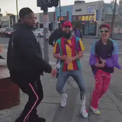Three men dancing on a city sidewalk