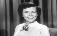 Woman winking and pointing to head