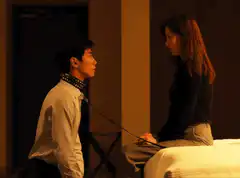 Woman pulls leash on kneeling man
