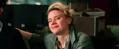 Kate McKinnon smirking and resting her chin on her hand