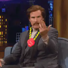Will Ferrell wearing a lei and making a hand gesture