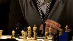 Man knocks over chess pieces in defeat