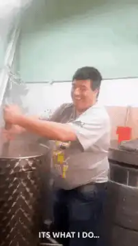 Man stirring pot laughing