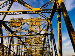 Yellow steel bridge structure against blue sky