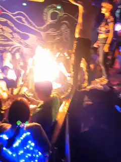 shirtless man dancing on stage near fire
