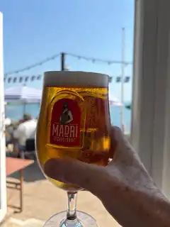 Hand holding Madri beer glass