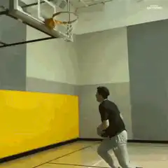 Man bounces basketball off wall into hoop