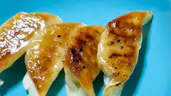 pan-fried gyoza dumplings on blue plate