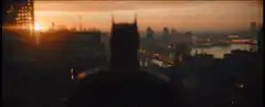 Batman silhouette overlooking city at sunset