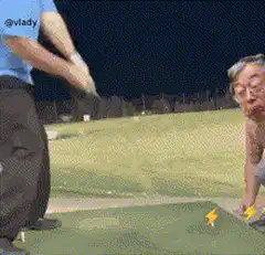 Man swings golf club at head on tee
