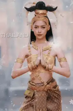 Woman in traditional Thai costume with hands in prayer