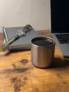 watch on notebook next to coffee cup