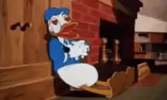 Donald Duck sitting by fireplace with floating hearts