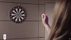 Woman throws dart and points at team