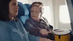 Boy playing drums on airplane seat