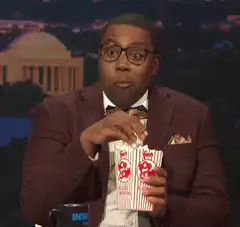 Comedian eating popcorn with wide eyes