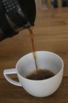pouring coffee into a white cup