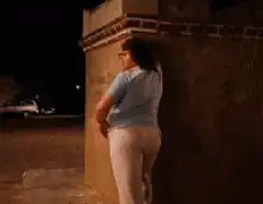 Woman leaning against wall at night