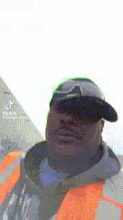 Man in safety vest salutes and points