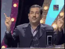 Man gesturing with both hands on stage