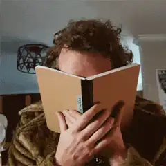 Man reading book and reacting