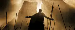 Silhouette figure with arms outstretched in cave