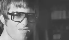 Man with thick glasses pursing lips