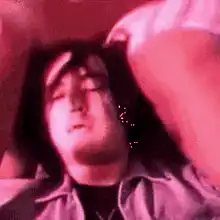 Man lying down with legs over face