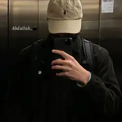 Man in cap taking mirror selfie in elevator