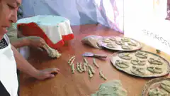 Woman rolling dough into small pieces