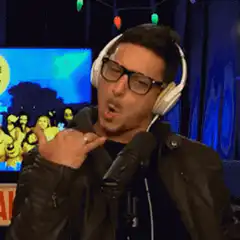 John Leguizamo singing with headphones