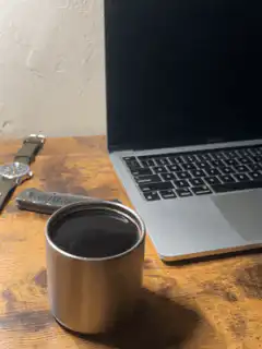 Metal cup on desk next to laptop