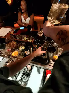 bartender pouring drink at bar