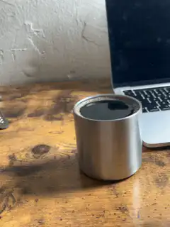 metal cup on wooden desk
