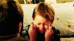 Boy crying and rubbing eyes
