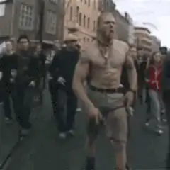 Shirtless man dancing in street