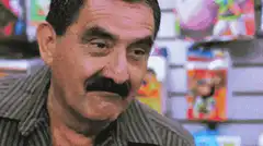 Man with mustache squinting and smiling