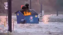 Blue dumpster on fire in flood