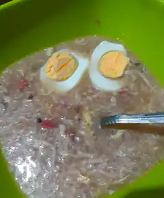 Egg halves in soup forming a face