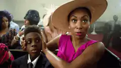 Woman in pink dress and hat making shocked faces