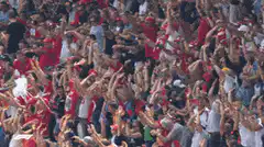 Crowd of fans jumping and waving flags